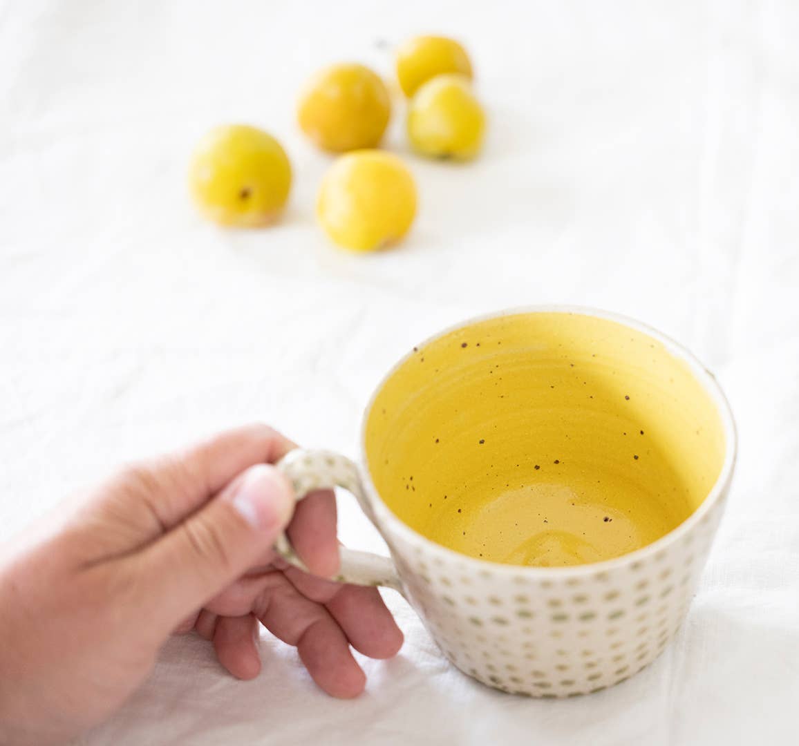 Coffee mug with light green polka dots yellow glaze